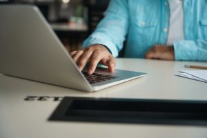 Close up photo of male typing on laptop