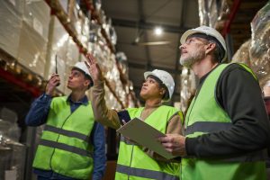 Group of workers in warehouse doing stock review storage management
